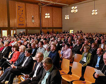 Menschen sitzen in einer Halle