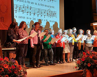 Pianist und Chor auf einer Bühne