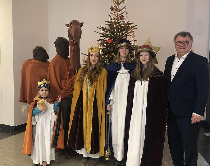 Kinder als Sternsinger mit Stern und Kamel vor dem Weihnachtsbaum im Rathaus mit OB Brand