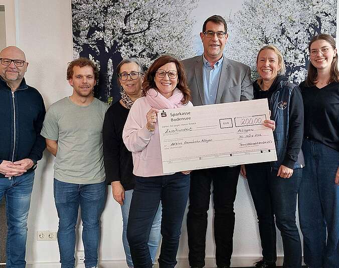 Gruppebild mit übergroßem Scheck