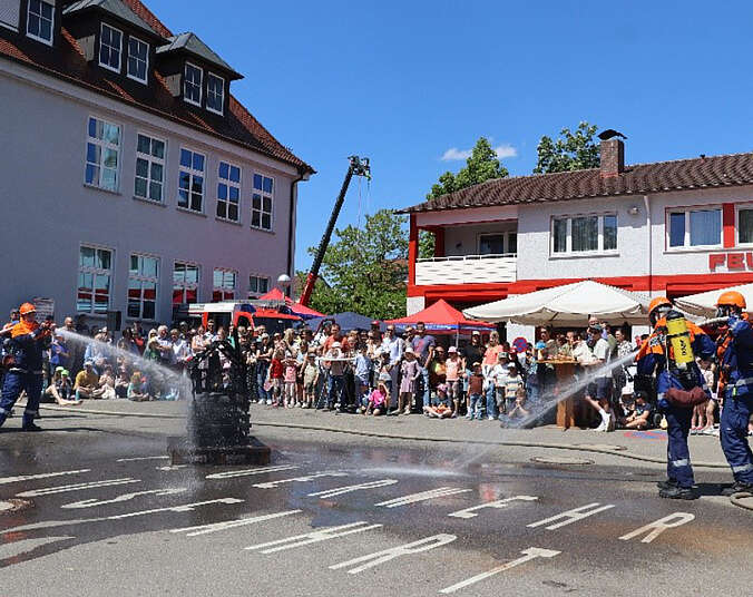Jugendlichen in Feuerwehruniform beim Löschen
