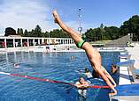Junge macht einen Handstand und spring ins Wasser.