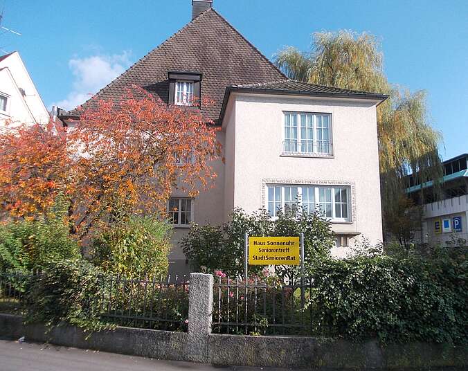 Haus mit weißem Giebel und Sträuchern