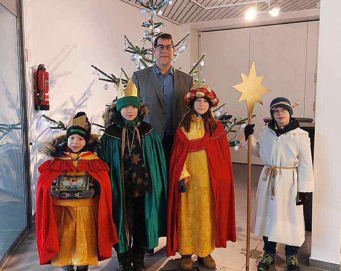 Gruppenbild Mann und Kinder als Sternsinger bekleidet