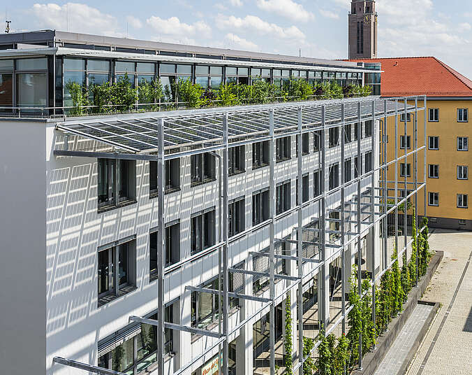Blick von oben auf begrünte Dachterrasse und Fassade des Technischen Rathauses