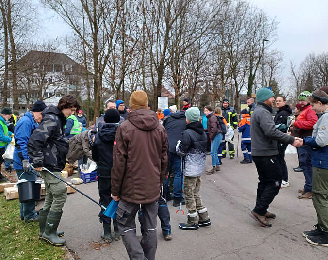 Männer und Frauen mit Müllzangen.