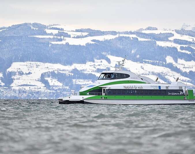 Katamaran auf dem Bodensee im Hintergrund die schneebedeckten Alpen.