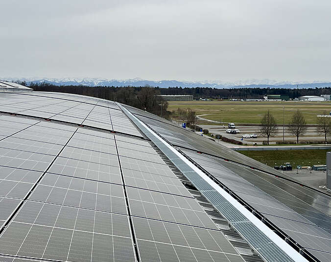 Photovoltaik-Module auf Messedach, im Hintergrund Alpenpanorama