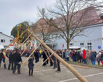 Meschenmenge auf einem Platz beim Aufstellen des Narrenbaums