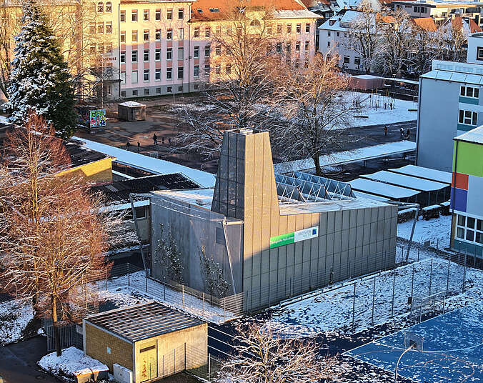 Vogelperspektive auf das Gebäude einer Energiezentrale, im Hintergrund die Pestalozzischule