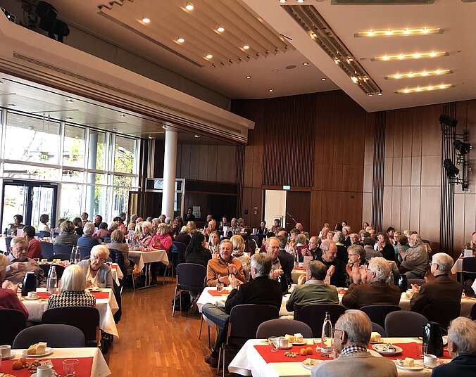 Viele Menschen sitzen an tischen. (Foto: Stadt Friedrichshafen)
