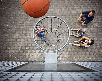 Kind wirft Basketball in Basketballkorb