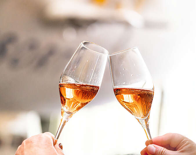 Zwei Champagnergläser im Hintergrund ein Zeppelin NT unscharf.