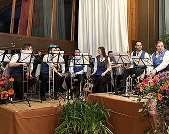 Gruppe von Musikanten sitzen auf einer Bühne