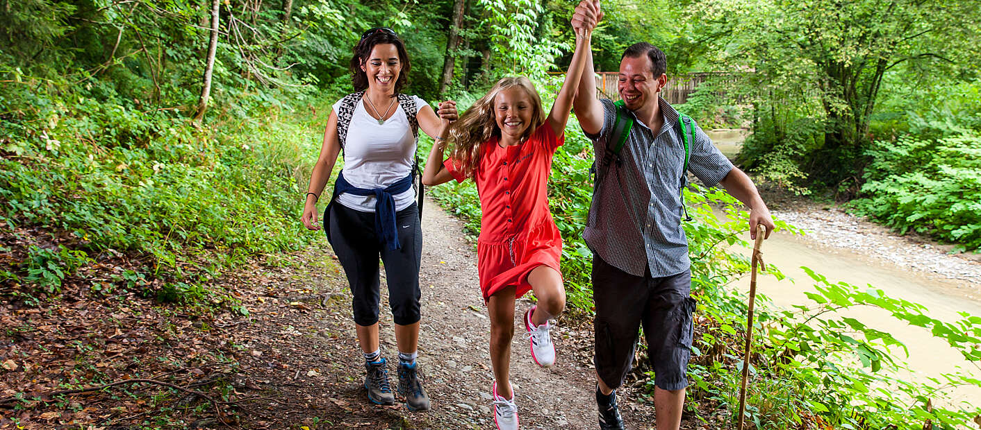 Familie wandert am Bach entlang